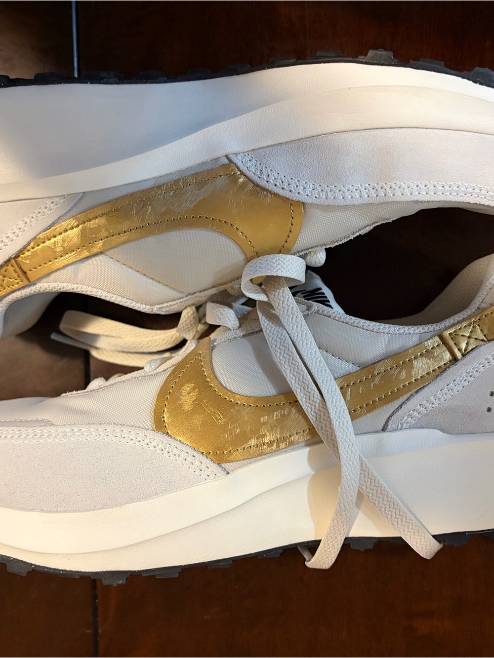 Nike Women's White Sneakers with Metallic Gold Swoosh Accent